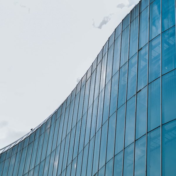 blue glass walled building under white clouds during daytime